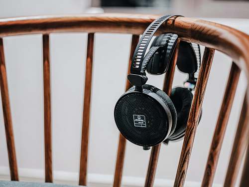 loudspeaker black cordless headphones on brown wooden chair speaker