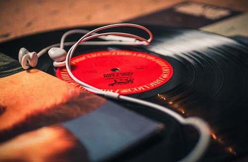 wristwatch closeup photo of earbuds on LP records headphones