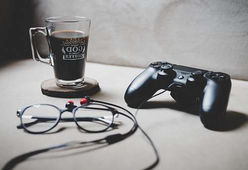 drink black Sony Dualshock 4 beside clear glass mug filled with coffee istanbul