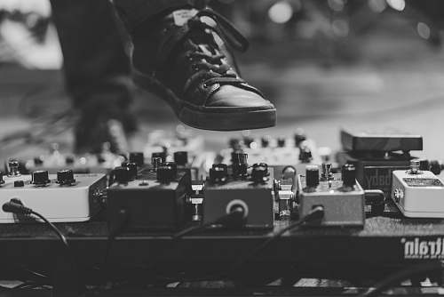 black-and-white person wearing black lace-up sneaker hitting the distortion stage