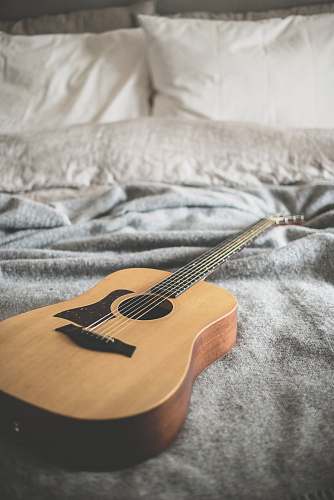 music brown acoustic guitar on gray blanket grey
