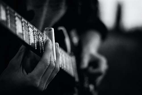black-and-white grayscale photography of person playing guitar music