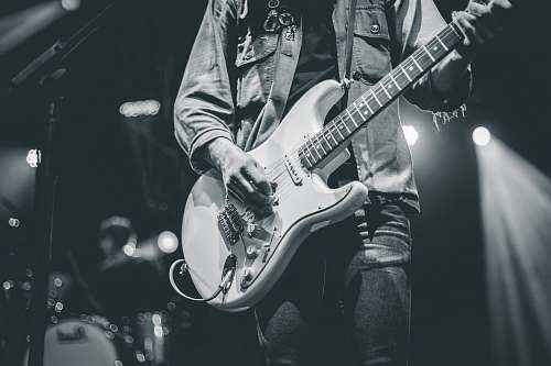 grey man playing electric guitar guitarist
