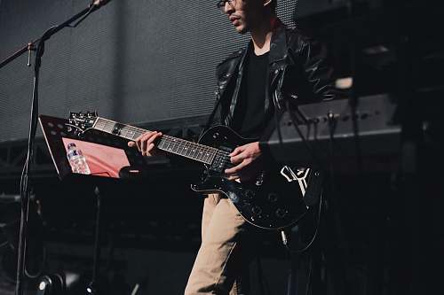 person man playing guitar on stage guitarist