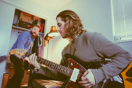 musician man playing guitar while the other sings guitarist