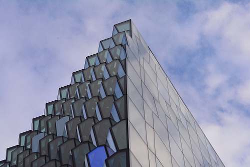 iceland low angle photography of glass building under cloudy sky at daytime building