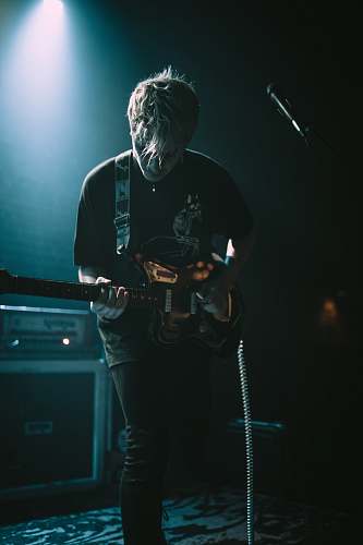 people band guitarist under spot light person