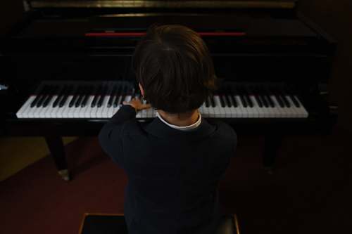 person boy playing a piano performer