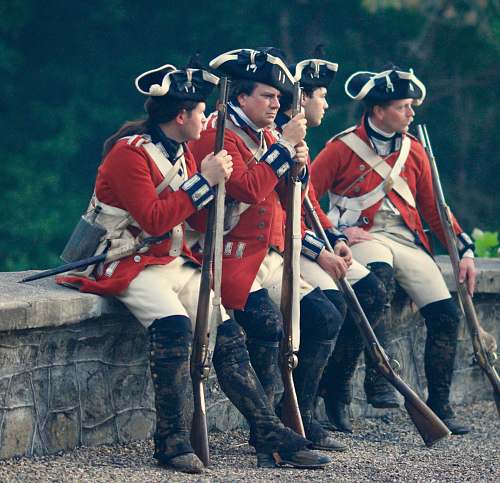 person four men in uniforms holding rifles people