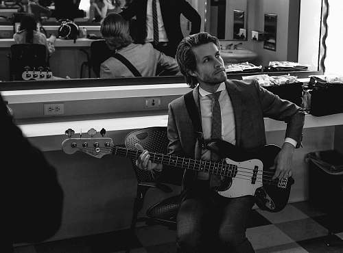 guitar grayscale photography of man wearing suit holding guitar black-and-white