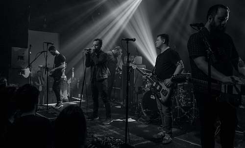person group of people performing on stage black-and-white