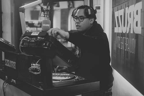 person man in black long sleeve shirt playing dj controller black-and-white