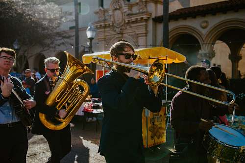 person man in black long sleeve shirt playing trumpet tuba