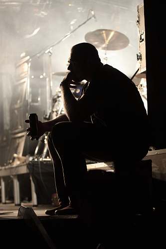 person man in black t-shirt sitting on chair apparel