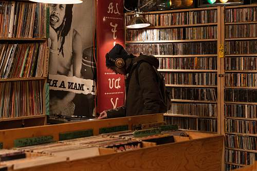 furniture man in hoodie and headphones standing inside record store shelf
