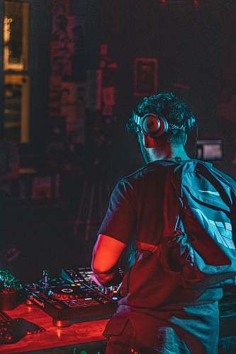 person man in red shirt with blue and black backpack dj