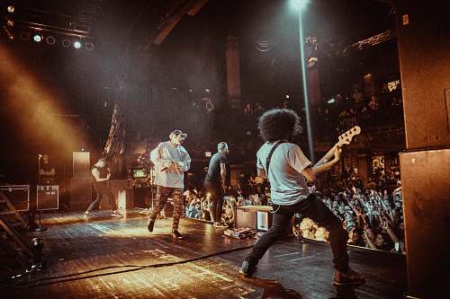 person man performing on stage together with his bandmates people