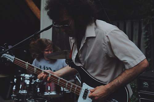 people man playhing guitar beside man playing drums person
