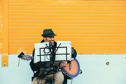 person man playing brown and black acoustic guitar people
