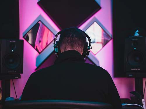 person man wearing black headphones near two PA speakers people