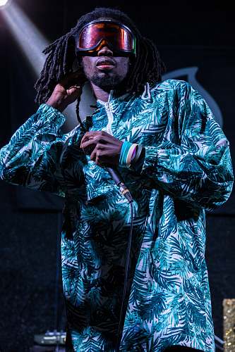 person man wearing floral dress shirt with braided hair people