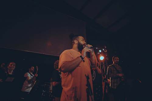 person man wearing yellow shirt holding microphone musical instrument
