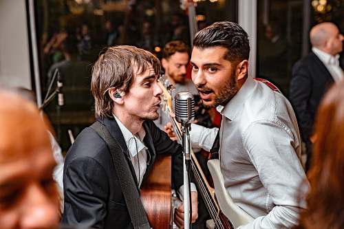 person men playing guitar and singing musician
