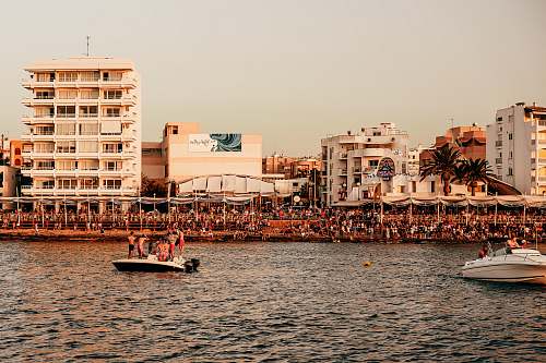 person people riding on boat on sea near buildings during daytime boat