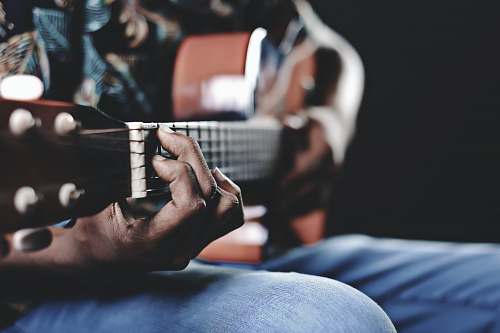 person person playing a brown guitar people