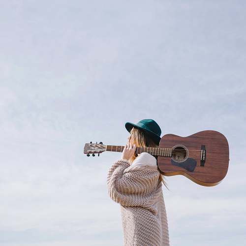 person woman carrying brown acoustic guitar people