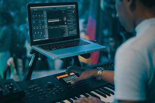 colombia person playing electronic keyboard while recording computer