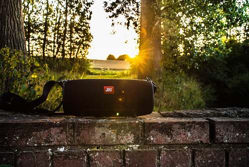 rest black JBL portable speaker on brick bench brick wall