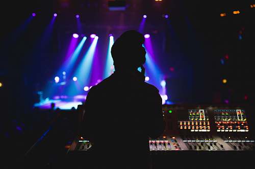 sound silhouette photography of DJ mixing a music show
