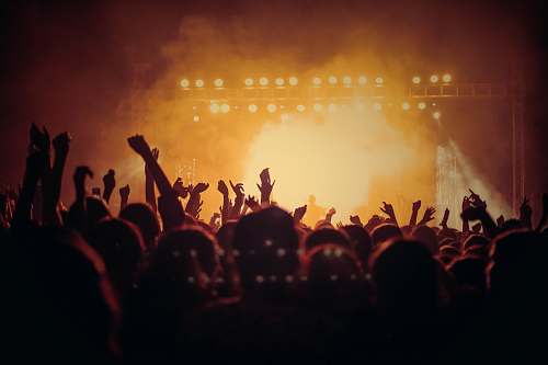 concert band performing on stage in front of people crowd
