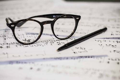 glasses black framed panto-style eyeglasses beside black ballpoint pen savoy