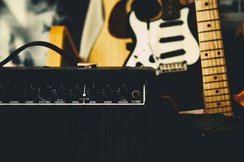 guitar black guitar amplifier beside electric guitar electric guitar