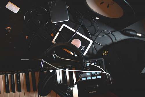 headphones flat-lay photo of headphones, MIDI keyboard, and speaker on black surface headphone
