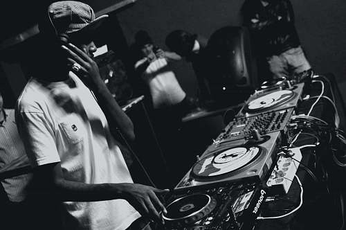 grey grayscale photo of man playing DJ mixing console black-and-white
