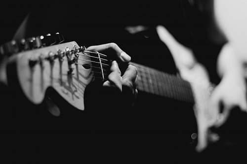 guitar grayscale photography of person playing electric guitar black-and-white
