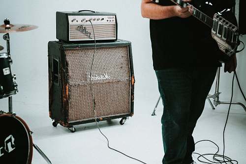 person guitar amplifier near drum instrument human