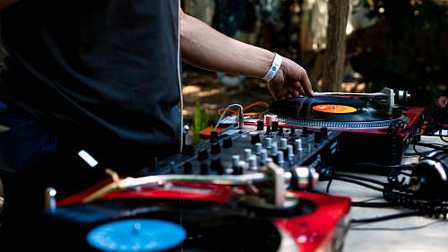 human man in black shirt using DJ controller dj