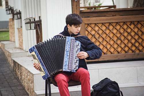 accordion man playing blue accordion during daytime leisure activities