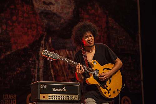 guitar man playing brown and black electric guitar musician