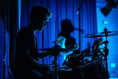 blue man playing drum set drummer