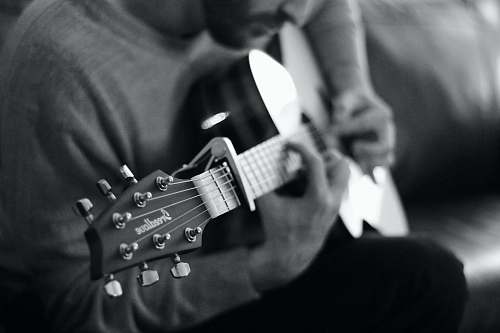 black-and-white man playing guitar grayscale photo musician