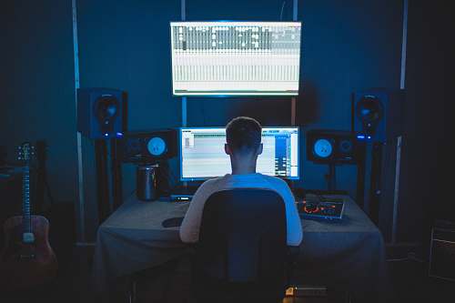 guitar man sitting in front of computer leisure activities