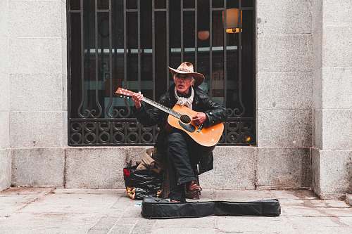 human man sitting on chair playing guitar musician
