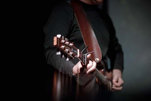 guitar person playing brown guitar instrument