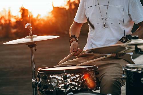 human person playing drum during golden hour person