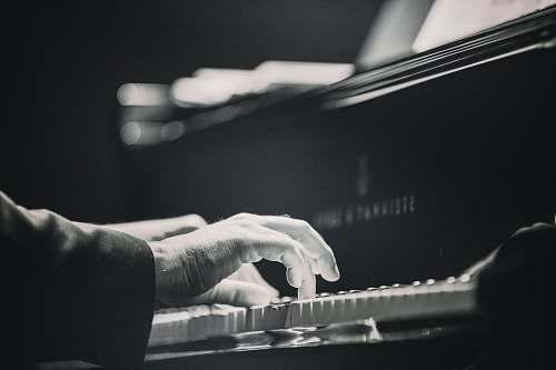 grey person playing piano piano